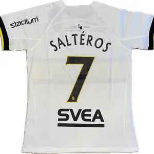 Säljer en fotbollströja från AIK med Salétros #7 på ryggen. Tröjan är en reprint. Lite smuts enligt sista bilden. Storlek: M. Ansvarar ej för postens slarv. Endast handtvätt gäller, gnugga ej på blöta prints.