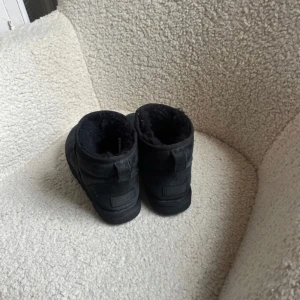 UGG Mini svarta - Ett par Uggs mini (obs inte ultra mini) 🤍 Dem är i väldigt fint skick då dem enbart är använda några gånger då jag har andra uggs 🥰 stl 36 👌 nypris 1700kr