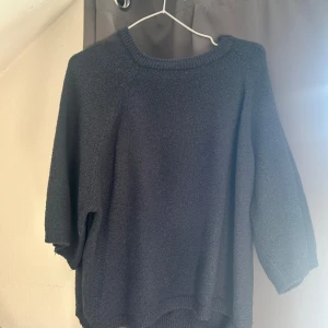 Svart stickad tröja - Säljer en mysig marinblå stickad tröja. Den har en enkel design med långa ärmar och en rund halsringning. Perfekt för kyliga dagar och kan enkelt matchas med olika outfits. Passar både till vardags och lite mer uppklädda tillfällen.
