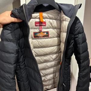 Parajumpers jacka - Äkta Parajumpers jacka, grå/svart färg. Ägt 1,5 år men kommer aldrig till användning, ej riktigt min stil. Har krage, två dragkedjor, QR-kod på insidan samt security pocket på insidan. Pris går att diskuteras vid snabb affär. ❤️