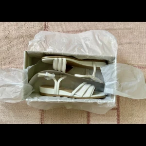 Vita sandaler - Tamiris  - Helt nya sandler från Tamiris, aldrig använda, köpt 2024 - original pris 1000kr. Säljer då de är för stora för mina fötter.  Skafthöjd: 6 cm Klackhöjd: 2.5 cm