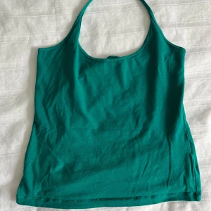 Grön ärmlös linnetopp - Snygg turkos halterneck topp perfekt för sommardagar. Toppen har en enkel och stilren design med halterneck. Passar perfekt till både jeans och shorts för en avslappnad look.