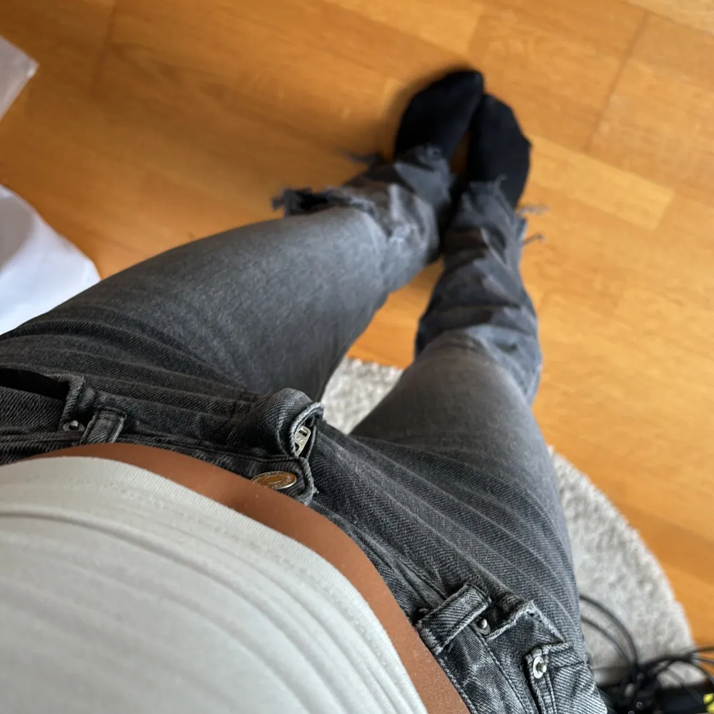 Säljer dessa super fina jeans från Gina Tricot i storlek 36. De är mörkgrå och bootcut med ett hål vid ena knät . Jeans & Byxor.