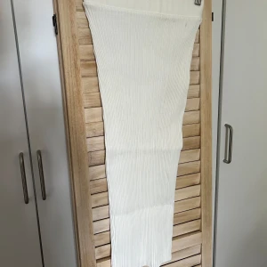 Vit ribbad kjol från Zara - Säljer en superfin vit ribbad kjol från Zara. Den är lång och har en tight passform som verkligen framhäver figuren. Perfekt för både vardag och fest! 🥰Materialet är extremt stretchigt och skulle passa allt från xs-m