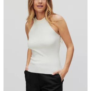 Vit ärmlös topp - Snygg och stilren vit ärmlös topp i ett mjukt material. Perfekt för både vardag och fest. Den har en tight passform som framhäver figuren.