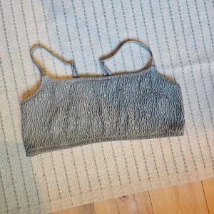 Grå smockad tubtopp - grön bikinitopp, använd max 3 gånger. storlek L men sitter jätte bra på mig som vanligtvis har S/M