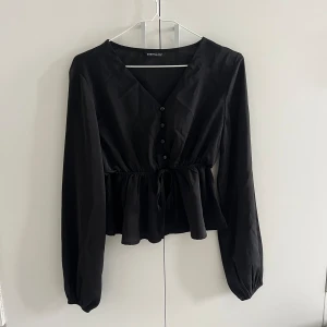 Svart blus  - Jättefin svart blus med både knytning och knappar.  