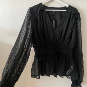 Svart blus  - Svart blus med svart prickar på.  Helt oanvänd från boohoo med prislapp på.