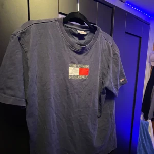 Blå t-shirt från Tommy Jeans - Säljer en snygg blå t-shirt från Tommy Jeans i storlek L. säljer då jag ej använder den 