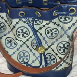 Säljer denna vackra Tory Burch bucket-väska i monogram i denna vackra färg.  Kontakta mig gärna för mer information och bilder