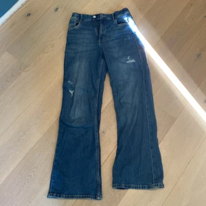 baggy bootcut jeans - säljer dessa snygga mörkblåa baggy bootcut jeans köpta från h&m, är lite slitna längst ner på benen. Man kan justera midjan.