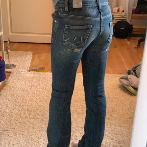 Lågmidjade jeans med tryck - Säljer ett sååå snygga och unika bootcut jeans med tryck på sidan av benet som är lågmidjade. Köpte på Vinted och säljer tyvärr vidare för att de var för små i midjan för mig 💕Midjemått: 36cm