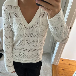 En virkad vit tröja  - En superfin vit virkad tröja men många fina detaljer! Den är v-ringad med en krage och snören! Hör av er vid frågor om mått eller liknande:)