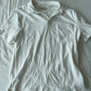 Vit kortärmad t-shirt från East West - Säljer en vit kortärmad piké från East West i storlek S. Pikén är gjort av frotté och har en klassisk krage samt en bröstficka. Perfekt för en avslappnad och stilren look. Den är i bra skick och redo för en ny ägare! Frågor? Skriv!