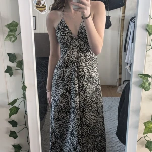 Lång sommarklänning - Säljer min klännig då jag inte haft någon användning av den. Den är rygglös och man kan justera hur den ska sitta runt bysten. I bra skick och knappt använd. Den är lite längre och slutar typ vid ankellängd (jag är 1,70).