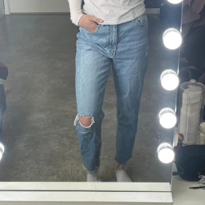 Blå jeans från ONLY - Säljer ett par snygga blå jeans från ONLY. De har en avslappnad passform med slitna detaljer vid knäet.  jeansen är oanvända och har bara provats på.