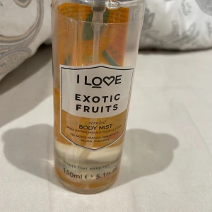 Exotic Fruits Body Mist från I Love - Säljer en fräsch och exotisk body mist från I Love med doft av mango, apelsin, melon och ananas. Flaskan är genomskinlig med en orange etikett och rymmer 150 ml. Perfekt för att känna sig uppfriskad och dofta gott hela dagen. Tillverkad i Storbritannien och fri från onödiga tillsatser. Perfekt för sommardagar eller när du vill känna dig extra fruktig! 🍍🍊. mer än halva flaskan finns kvar 