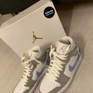 Air Jordan 1 mid ”Wolf grey” - Första bilden är från när de köptes, resten av bilderna är i befintligt skick.. väl omhändertagna och knappt använda. Väldigt sköna skor😊🤝🏼 Nypris 3500kr, ge gärna prisförslag!