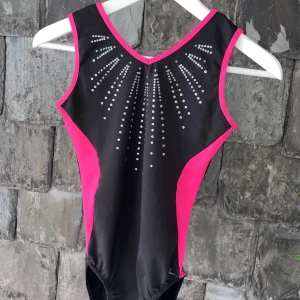 Gymnastikdräkt  - Säljer en svart och rosa gymnastikdräkt med fina detaljer på framtidan. Dräkten är sparsamt använd och har inga defekter. Dräkten är köpt på decathlon, priset kan diskuteras vid snabb affär 🩷