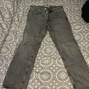 Grå jeans från Zara - Snygga grå jeans från Zara i en klassisk straight fit. De har en midwaist design och är perfekta för en avslappnad stil. Tillverkade i ett slitstarkt denimtyg.