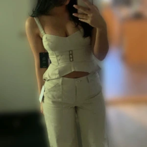 Beige cargopants och matchande topp - Beigt cargo-set med mid-waist byxor och matchande topp med tunna band. Nypris 600kr. Endast använd 1 gång. 