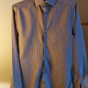 Rutig skjorta från Riley - Snygg rutig skjorta från Riley i slim fit. Skjortan har långa ärmar och knappar framtill. Perfekt för en stilren look.