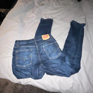 Levis 512 strl 175cm / 29/32 - Säljer ett par klassiska blå jeansbyxor från Levi's med fem fickor och en ikonisk läderpatch på baksidan. Perfekta för en avslappnad stil.