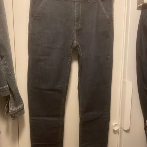 Mörkblå jeansbyxor - Snygga mörkblå jeansbyxor med klassisk design. De har en normal passform och är perfekta för en avslappnad stil. Byxorna har fickor fram och bak samt knapp- och dragkedjestängning.