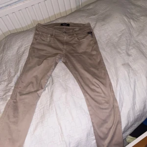 Beige Jeans från Replay - Snygga beige byxor från Replay med klassisk femficksdesign. Byxorna har en normal passform och är perfekta för en avslappnad stil. Tillverkade i ett mjukt och bekvämt material. Som nyskick