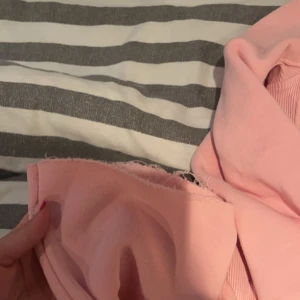 Rosa hoodie från russemerch  - Mysig rosa hoodie från russemerch med dragkedja och ribbade muddar. Perfekt för en avslappnad stil. Den har en justerbar huva med vita snören. Tröja xs byxorna xxs sprättade upp dom längds ner, har aldrig använt för köpte fel storlek så dom är för korta för mig och är 1,60, dom är på gränsen korta men gillar när byxor släpar det för säljer jag dessa. 