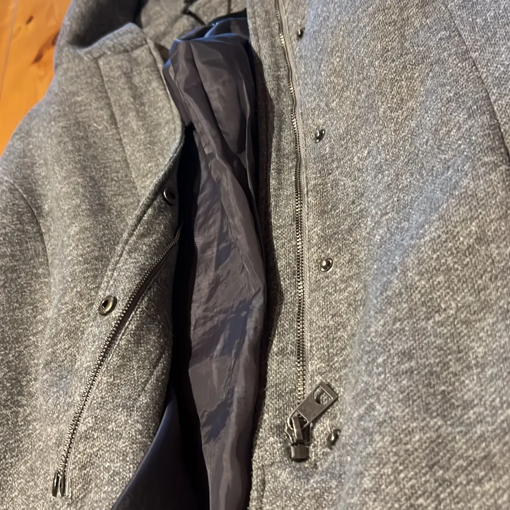 Snygg grå kappa från Vero Moda med huva och dragkedja. Perfekt för kyliga dagar med sin stilrena design och praktiska detaljer. Kappan har långa ärmar och en mjuk insida för extra komfort.. Takit.