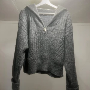 Grå stickad tröja med dragkedja - Mysig grå stickad tröja med dragkedja och ribbade detaljer. 