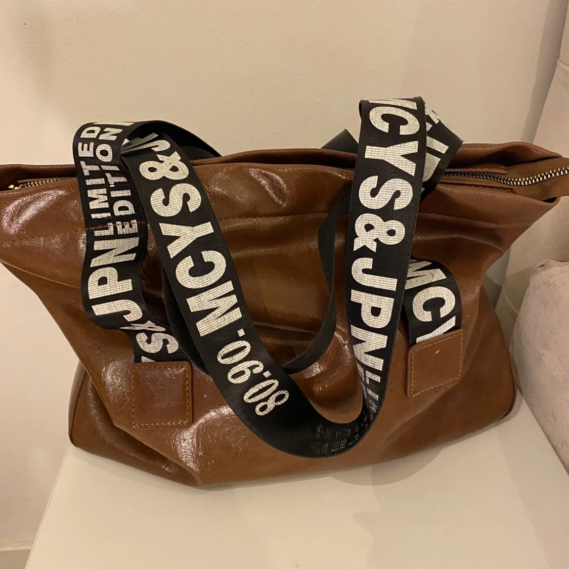 Brun axelväska med tryckta band