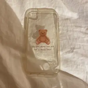 Säljer ett transparent mobilskal med ett sött nallemotiv och texten 'You are never too old for a teddy bear'. Perfekt för att ge din telefon en gullig touch. 💕