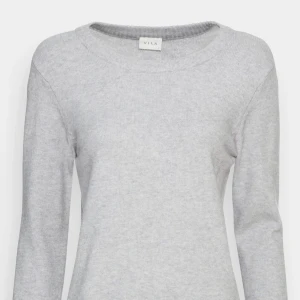 Grå tröja från Vila - Säljer en stilren grå tröja från Vila. Den har en klassisk design med långa ärmar och rund halsringning. Bra skick. Nypris 379. säljer för 150kr