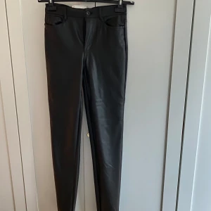 Svarta skinn byxor  - Snygga svarta byxor från Only i modellen Emily. De är högmidjade och har en rak passform som slutar vid ankeln. Perfekta för en stilren look.