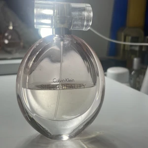 Calvin Klein Sheer Beauty Parfym - Elegant parfym från Calvin Klein. Doften Sheer Beauty har en fräsch och feminin karaktär, perfekt för den som söker en lätt och upplyftande doftupplevelse. 