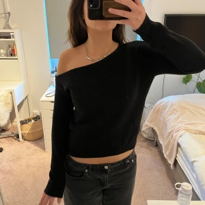 Svart offshoulder tröja - Snygg svart offshoulder tröja med ribbad design. 