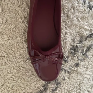 Vinröda ballerinaskor med rosett - Snygga vinröda ballerinaskor i lack med en söt rosett på tån. Perfekta för en stilren look.💕