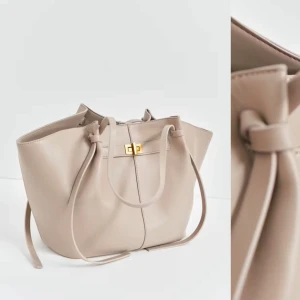 Beige handväska med gulddetaljer - Snygg väska från Gina tricot! Mycket bra skick!