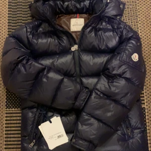 Marinblå Moncler Maya  - Snygg och varm marinblå Moncler Maya med dragkedja och hög krage. Stolerken är  2 som motsvarar M. Perfekt för kyliga dagar. Prislapp Finns kvar.Perfekt julklapp till jul. Daglig kostnad på denna jacka ligger på ungefär 18000kr. Mitt pris 7000  men pris går att diskuteras. Skriv gärna till mig för bättre bilder eller för funderingar//Alex😇