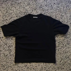 Svart Airsm t-shirt från Uniqlo - Säljer en klassisk svart t-shirt från Uniqlo i storlek S. T-shirten är kortärmad och tillverkad i ett mjukt material, perfekt för en stilren look.