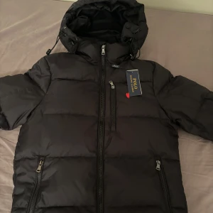 Svart dunjacka från Polo Ralph Lauren - Fet puffer från Raplh Laruen. Märkte att det var en size för lite och kunde inte lämna tillbaka. (SIZE: S) 100/10 skick. Har bara testat den inomhus. Håller värme bra och är väldigt bekväm. (Kan sänka pris, skriv privat).