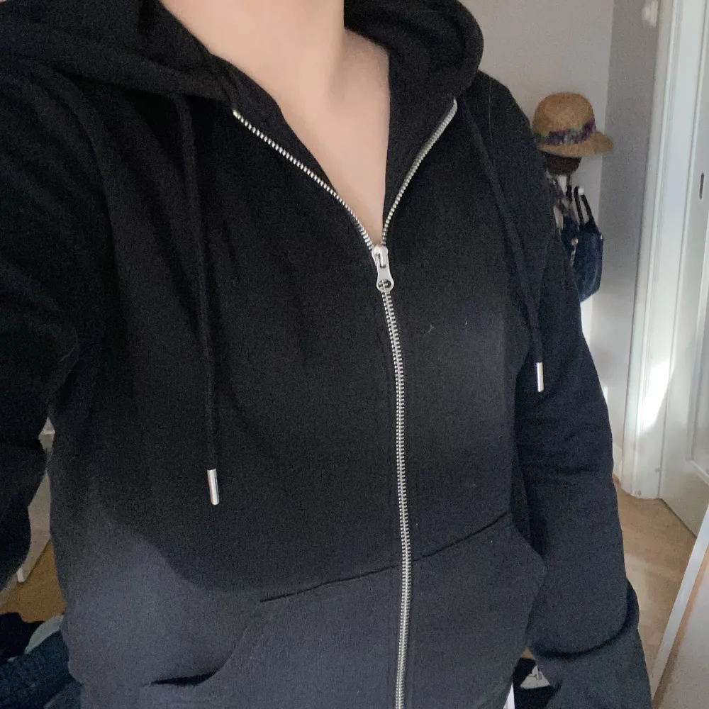 En svart zip hoodie med en silvrig dragkedja  i storklek M från H&M. En luva och materielet inom varan är mjuk och fluffigt. . Hoodies.