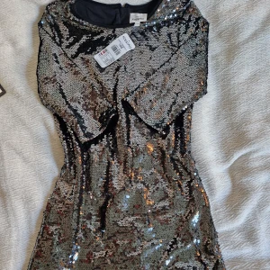 Glittrig paljettklänning  - Oanvänd Glittrig paljettklänning med lapparna kvar i stolek 146 från kapphal, 