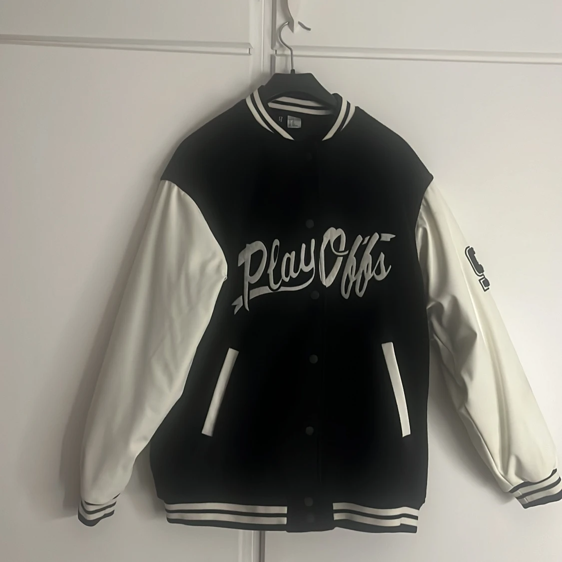 Svart och vit bomberjacka med PlayOffs-tryck