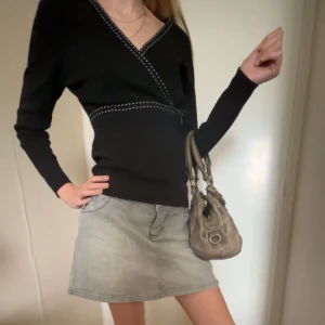 svart omlottröja💘 - Säljer denna jättefina omlottröja som är perfekt till hösten 💋 Tröjan är i bra skick och köptes secondhand för 215kr 💘Tar emot prisförslag och är öppen för frågor!  💋 Mer information om materialet, storlek osv finns på lappen (bild 4)