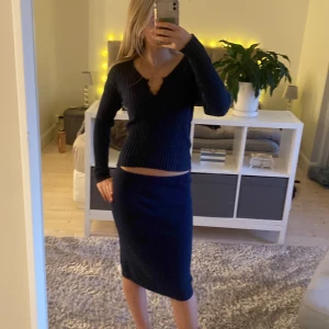 Mörkblå ribbat set från ONLY och sassy - Säljer en snygg mörkblå ribbat set från ONLY och sassy. Den har en v-ringad design och långa ärmar, perfekt för höst och vinter. Tröjan är i storlek M och sitter bekvämt med en slim passform. Perfekt för både vardag och festliga tillfällen! De är ej av samma märke men har exakt samma färg så jag säljer det som ett set, men om nån vill köpa nåt separat så skriv bara så ordnar vi! Tröjan säljs säljs för 200kr och kjolen för 150kr om det köps separat. Säljer båda för 300kr