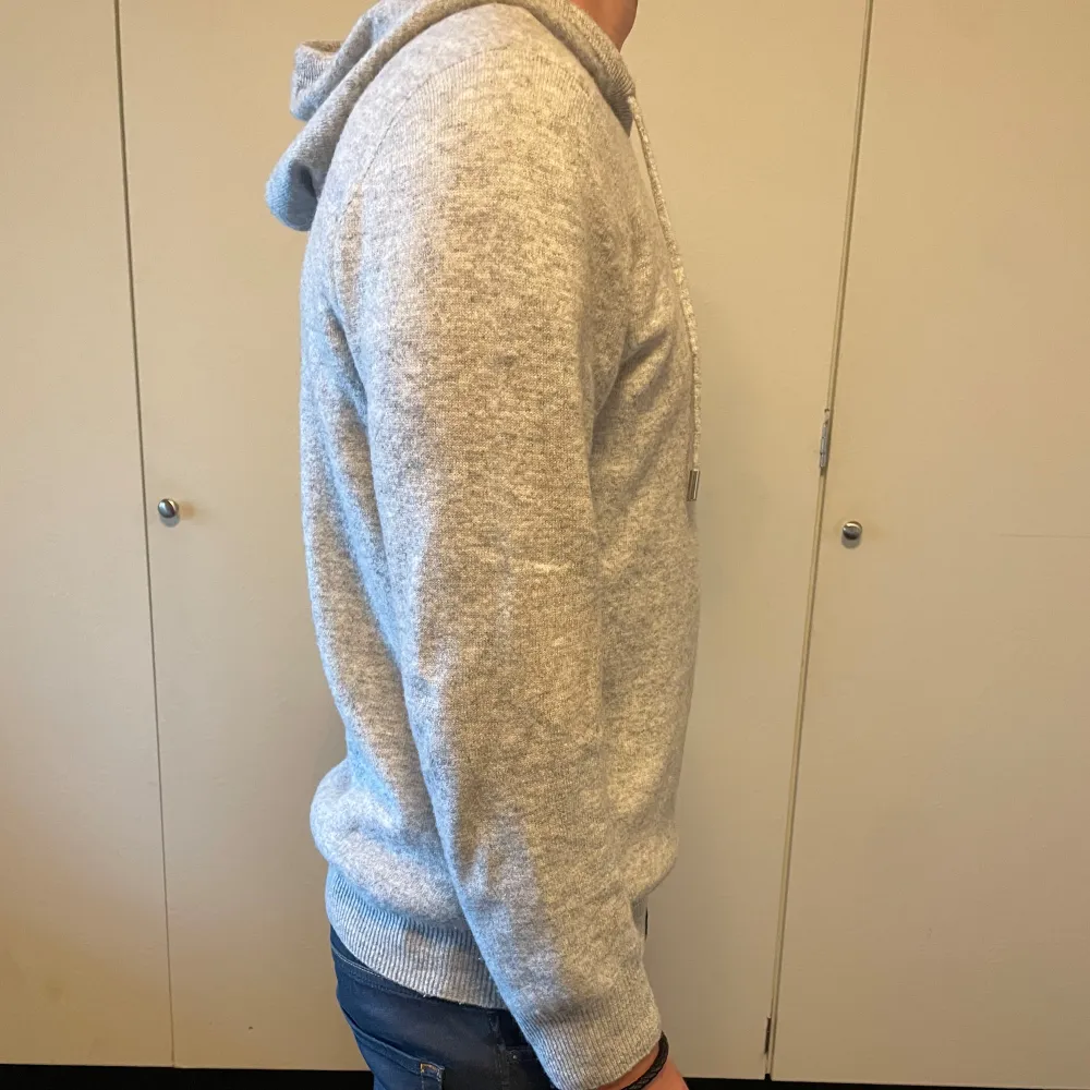 Säljer nu denna feta ljusgråa hoodie i 100% merinoull. Storleken är S men det finns även i M. Modellen är 177 cm lång. Hoodien är helt ny.. Hoodies.