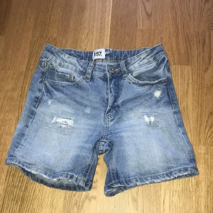 Ljusblå shorts - Ljusblå shorts som är slitna med flit.